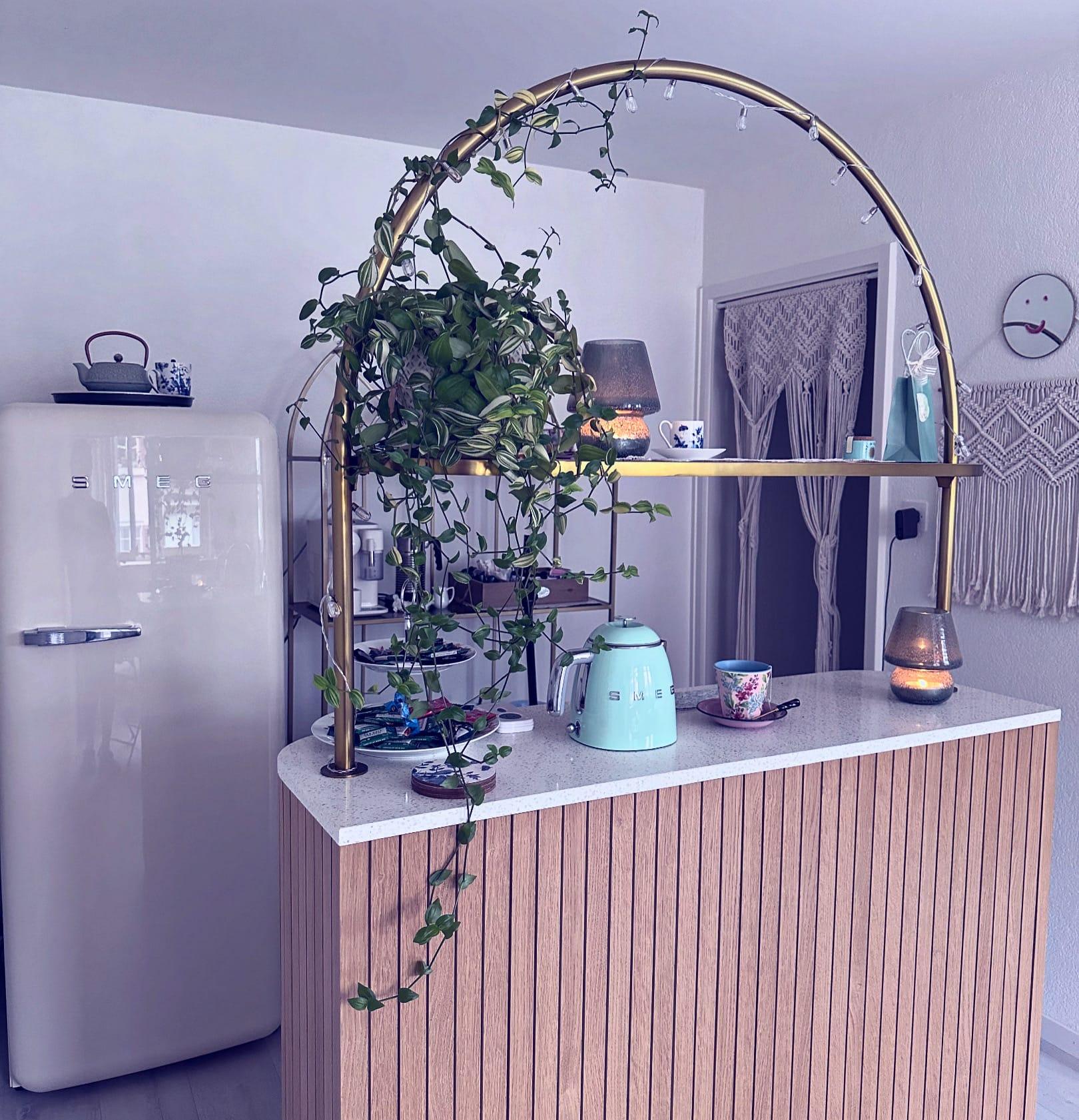Tee- und Kaffee-Ecke mit cremefarbenem Retro-Kühlschrank und goldenem Bogen im Salon