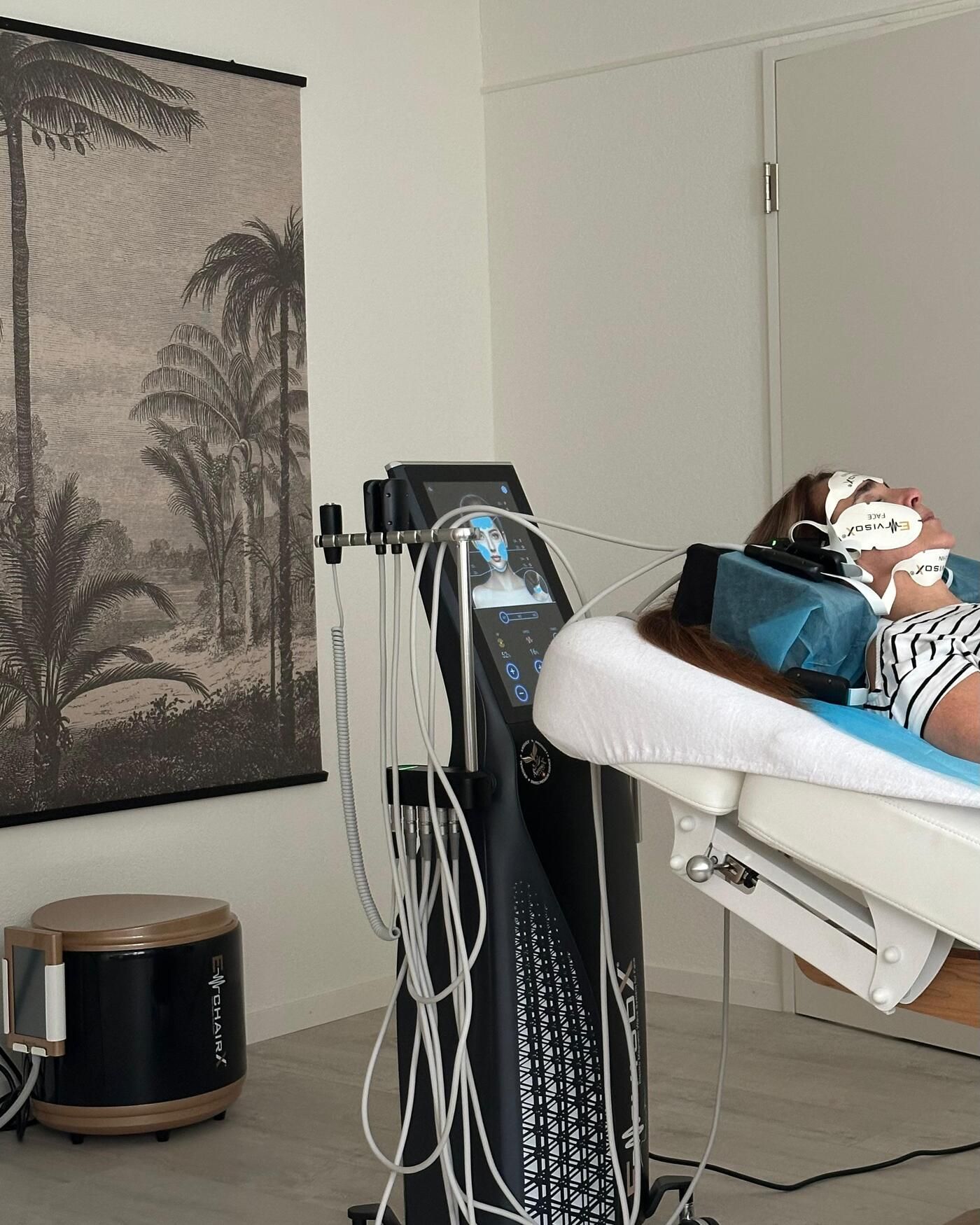 Klientin mit EMVisioX-Pads im Gesicht liegt auf der Liege im Behandlungsraum des Canelas Natural Beauty Center